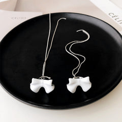 Weiße Ohrringe mit Schleife und Quaste