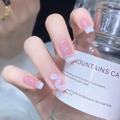 Manicura terminada con uñas usables con lazo rosa