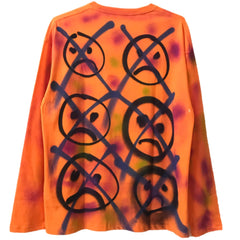 Suéter naranja con pintura en aerosol y sonrisa de Street Style