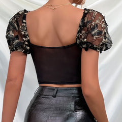 Top corto de malla con mangas abullonadas y bordado floral negro
