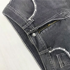 Vaqueros oscuros con bordado de calavera gótica