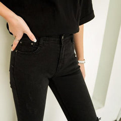 Pantalones elásticos negros con agujeros rotos por encima de la rodilla