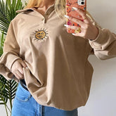 Beigefarbener, lockerer Pullover mit Polokragen und Retro-Sonnenstickerei