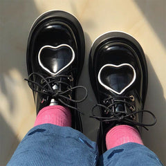 Botas gruesas con diseño de corazón y estética universitaria en negro brillante