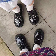 Botas gruesas con diseño de corazón y estética universitaria en negro brillante
