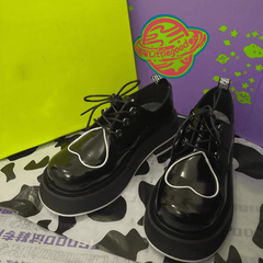 Botas gruesas con diseño de corazón y estética universitaria en negro brillante