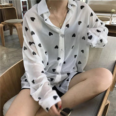 Blusa de manga larga con cuello de gasa blanca y corazones negros