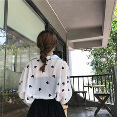 Blusa de manga larga con cuello de gasa blanca y corazones negros