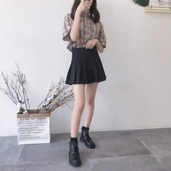 Botines planos de cuero negro con cremallera y hebilla metálica