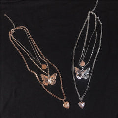 Collar con cadena fina y medallón de corazón con colgante de mariposa