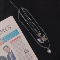 Collar con cadena fina y medallón de corazón con colgante de mariposa