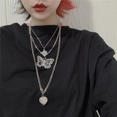 Collar con cadena fina y medallón de corazón con colgante de mariposa