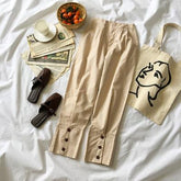 Pantalones casuales de cintura elástica color crema con botones cuadrados