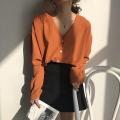 Blusa elegante y chic con escote en V en color negro, naranja y rosa