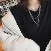 Collar con cadenas metálicas plateadas y insignias militares cruzadas