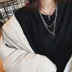 Collar con cadenas metálicas plateadas y insignias militares cruzadas