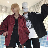 Chaqueta cortavientos con rayas laterales sueltas en color rojo oscuro y negro