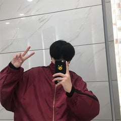 Chaqueta cortavientos con rayas laterales sueltas en color rojo oscuro y negro