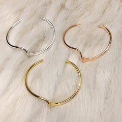 Elegante pulsera de plata dorada con diseño de ondas metálicas brillantes