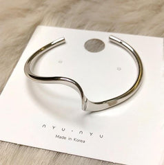 Elegante pulsera de plata dorada con diseño de ondas metálicas brillantes