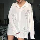 Blusa larga extragrande de gasa blanca con cuello negro y dibujos de caras