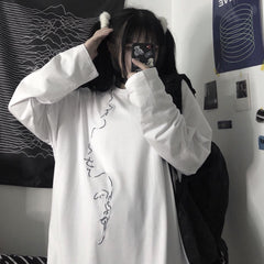 Camisa holgada blanca y negra con estampado de líneas y perfiles de caras