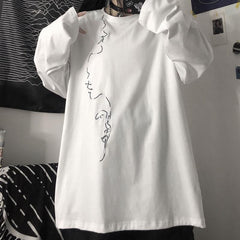 Camisa holgada blanca y negra con estampado de líneas y perfiles de caras