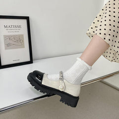 Sandalen mit glänzendem, cremeweißem und schwarzem Zehenbereich und Perlenband