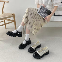 Sandalen mit glänzendem, cremeweißem und schwarzem Zehenbereich und Perlenband