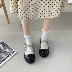 Sandalen mit glänzendem, cremeweißem und schwarzem Zehenbereich und Perlenband