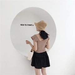 Top elegante con botones delanteros y hombros ondulados de punto