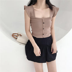 Top elegante con botones delanteros y hombros ondulados de punto