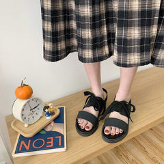 Flache schwarze ästhetische Sommersandalen zum Schnüren