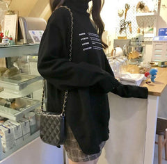 Suéter de punto negro con corte lateral largo y estampado de letras