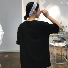 Camiseta oversize blanca y negra con gafas de sol de Mathilda Leon para niña dibujando líneas