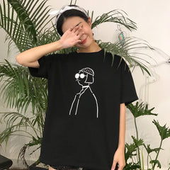 Camiseta oversize blanca y negra con gafas de sol de Mathilda Leon para niña dibujando líneas