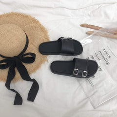 Sandalias planas abiertas con hebilla minimalista en blanco y negro