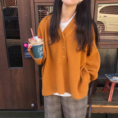 Suéter naranja con botones en el cuello azul oscuro de los años 90