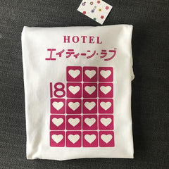 Camiseta blanca holgada con estampado de hotel rosa, estética suave
