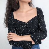 Blusa negra retro de lunares con mangas acampanadas