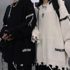 Suéter de punto blanco y negro con estética grunge rasgado