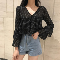 Blusa corta negra con cuello en V y lunares claros con volantes
