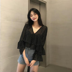 Blusa corta negra con cuello en V y lunares claros con volantes