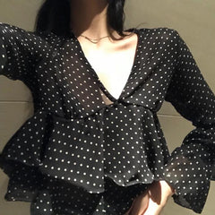 Blusa corta negra con cuello en V y lunares claros con volantes