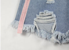 Shorts vaqueros azul claro con agujeros y líneas rosas laterales