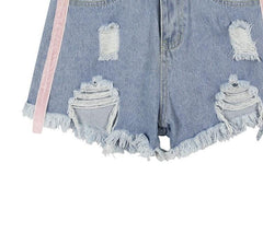 Shorts vaqueros azul claro con agujeros y líneas rosas laterales