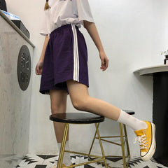 Pantalones cortos unisex con diseño grunge y rodillas largas con líneas deportivas laterales triples