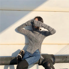 Suéter de punto gris con cuello alto y aberturas