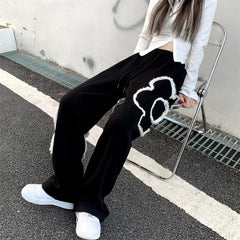 Pantalones deportivos negros holgados con estampado de flores grunge suaves