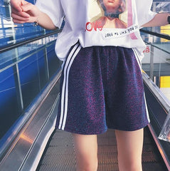 Shorts morados y negros con doble línea lateral por encima de la rodilla y brillantes